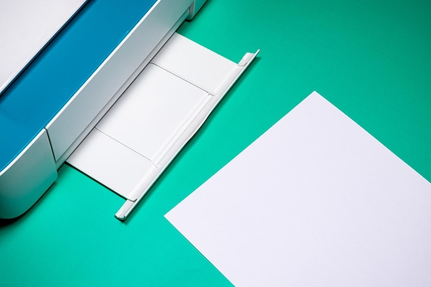Creatieve kantoor witte en blauwe printer op groen bureau met lege ruimte