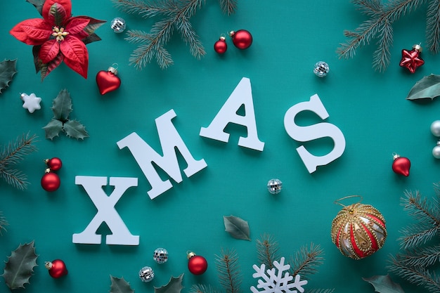 Creatieve kerst plat leggen met witte letters Xmas op levendig mintgroen textiel.