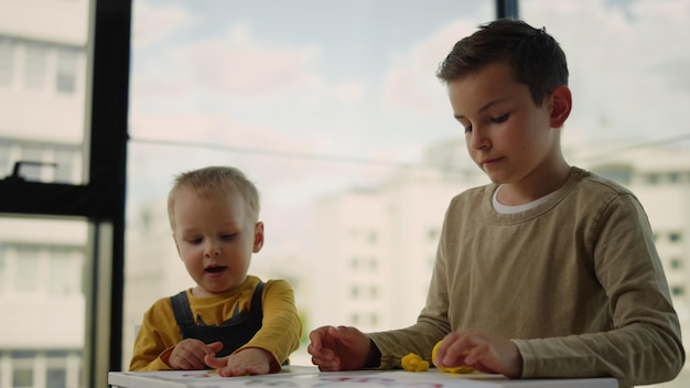 Creatieve kinderen die thuis modelleren van plasticine Broers en zussen die binnenshuis spelen