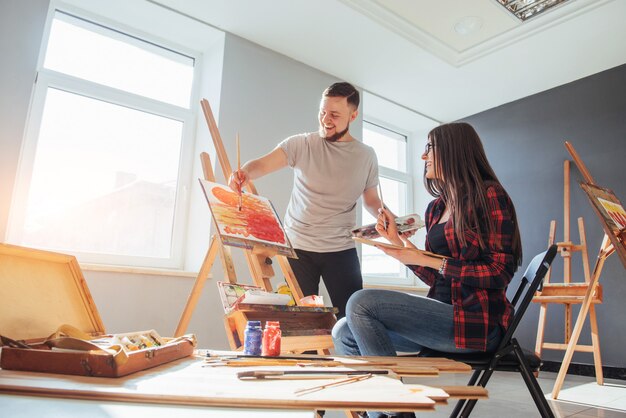 Creatieve kunstenaars schilderen een kleurrijk beeld op canvas met olieverf