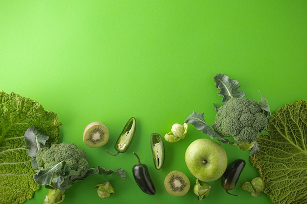 Creatieve lay-out food concept gemaakt van groene groenten en fruit op groene achtergrond