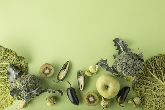 Foto creatieve lay-out food concept gemaakt van groene groenten en fruit op groene achtergrond