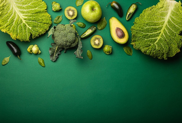 Creatieve lay-out food concept gemaakt van groene groenten en fruit op groene achtergrond