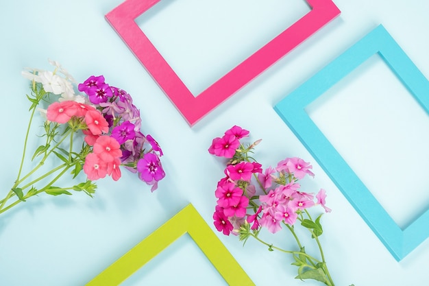 Creatieve lay-out gemaakt van bloemen en felgekleurde frames op blauw.