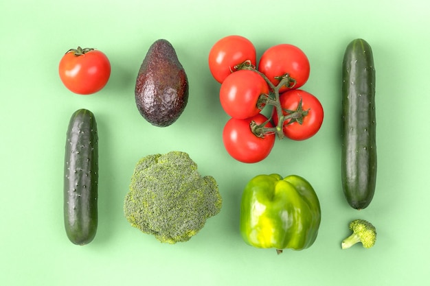 Creatieve lay-out gemaakt van peper, avocado, komkommer, broccoli en tomaat. Plat lag, bovenaanzicht. Voedsel concept.