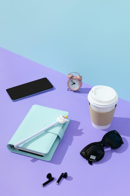 Creatieve lay-out met briefpapier koffiekopje en koptelefoon op paarse tafel