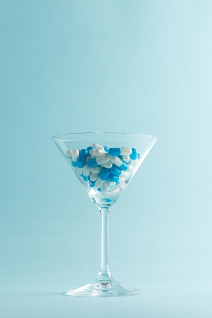 Creatieve lay-out met martini-glas vol blauwe pillen