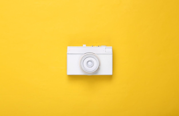 Creatieve lay-out Witte retro camera op gele achtergrond Minimalisme Concept art Modern stilleven Plat lag Bovenaanzicht