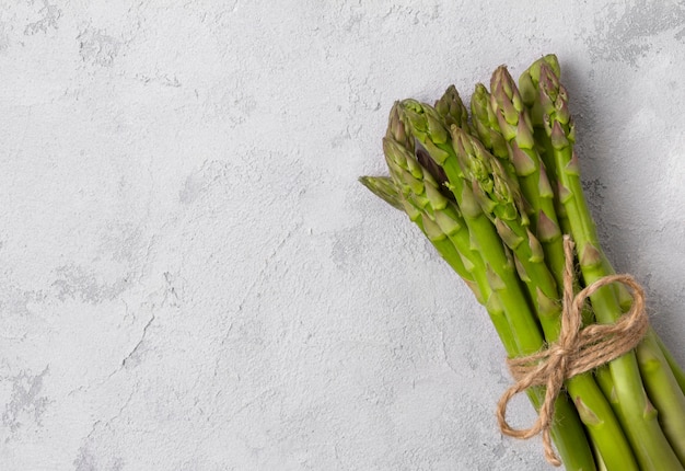 Creatieve minimale compositie van verse groene asperges op grijze betonnen tafel met kopie ruimte