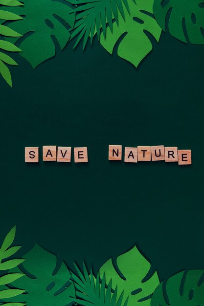 Creatieve mockup gemaakt van tropische bladeren met "Save Nature" belettering. Uitzicht van boven. Natuur concept.