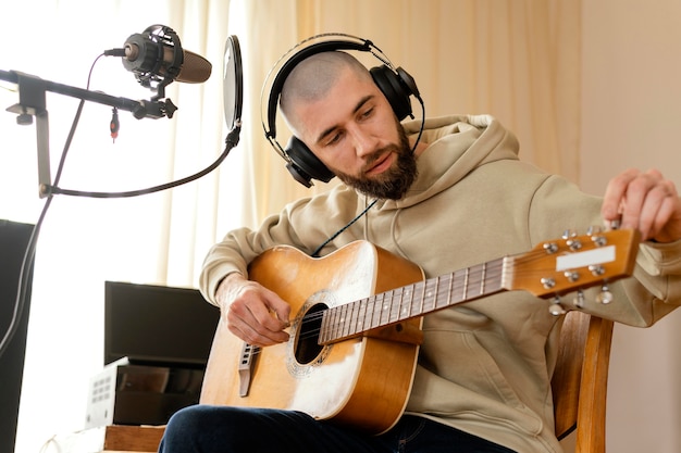 Foto creatieve muzikant die binnenshuis oefent