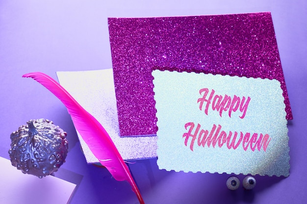 Creatieve paarse en roze Halloween tafel met zwevende roze pin quill, stapel glitterpapier en pompoenen