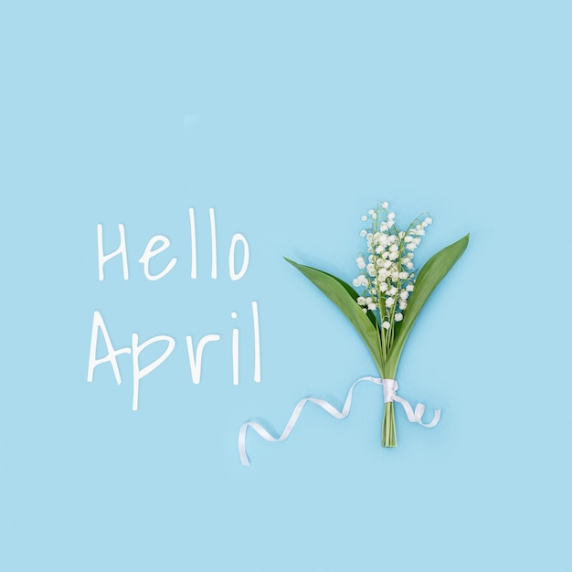 Creatieve platliggende compositie met lentebloemen witte lelietje-van-dalen op blauwe seizoensgebonden bloemen