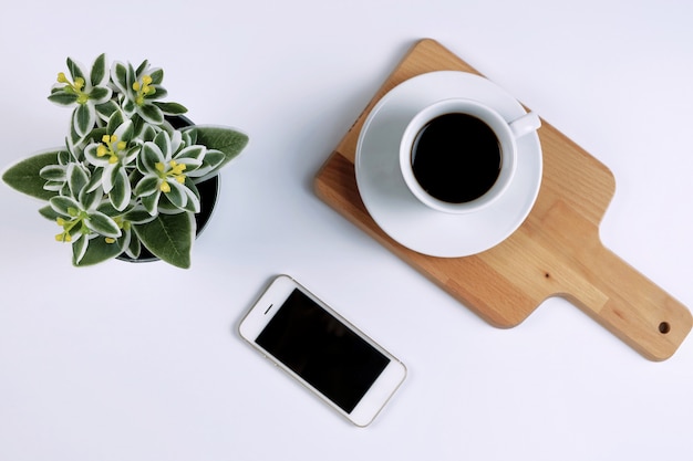 Creatieve platte lay-out van koffie, smartphone en plant