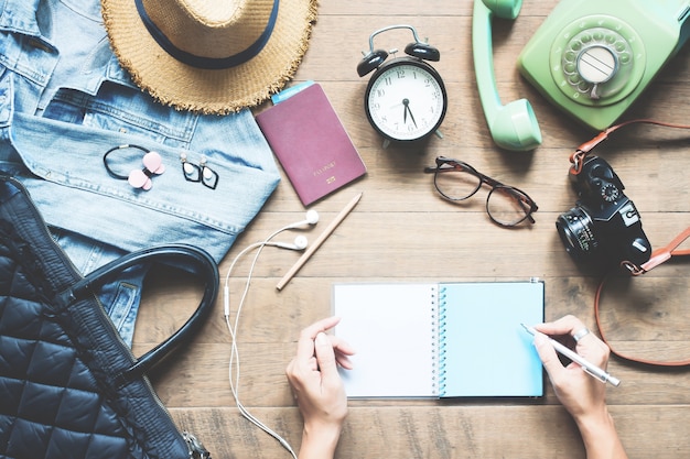 Foto creatieve platte lay-out van vrouwen handen planning vakantie vakantie met accessoires op houten werkruimte