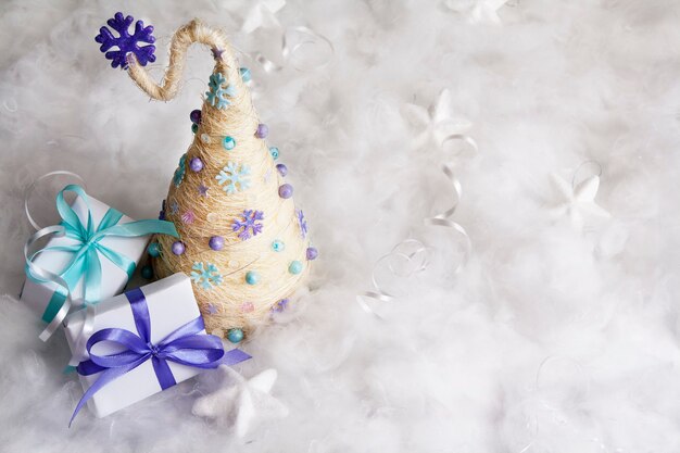 Creatieve vrolijke kerstboom met geschenken in de sneeuw met kopie ruimte. Vrolijk kerstfeest