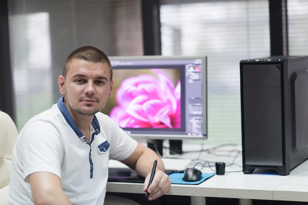 creatieve werker, foto-editor werkt aan een grafisch tablet op zijn desktopcomputer bij een klein opstartkantoor