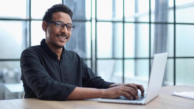 Creatieve zakenman werkt aan een bureau met laptop in een modern kantoor