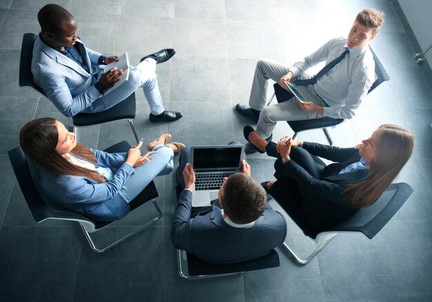 Creatieve zakenmensen ontmoeten elkaar in een kring van stoelen