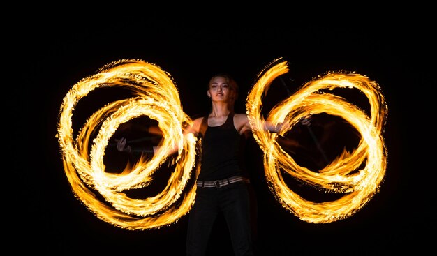 Creating incredible patterns of fire Sexy woman roll dragon staff in darkness Rotational fire staff manipulation Manipulating style Night performance Party festival Holiday celebration