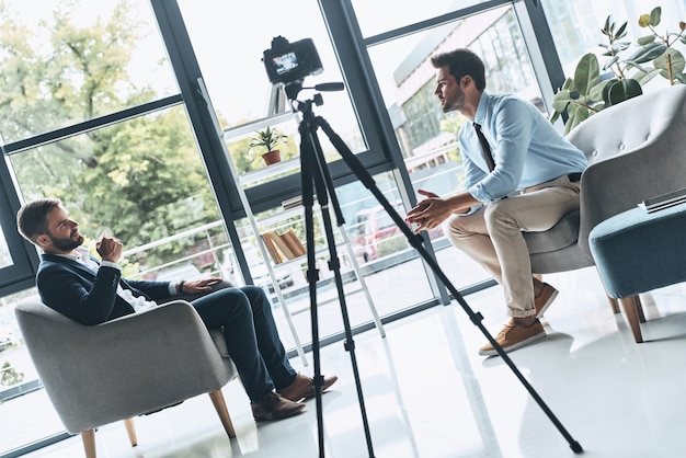 Photo creating interesting content. two young men in smart casual wear talking