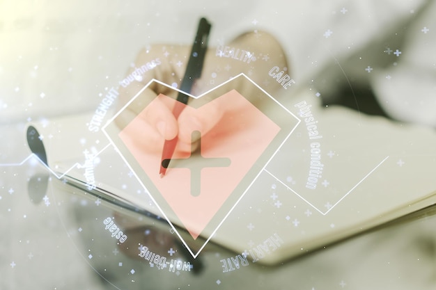 Creative abstract heart pulse hologram and man hand writing in diary on background online medical consulting concept Multiexposure