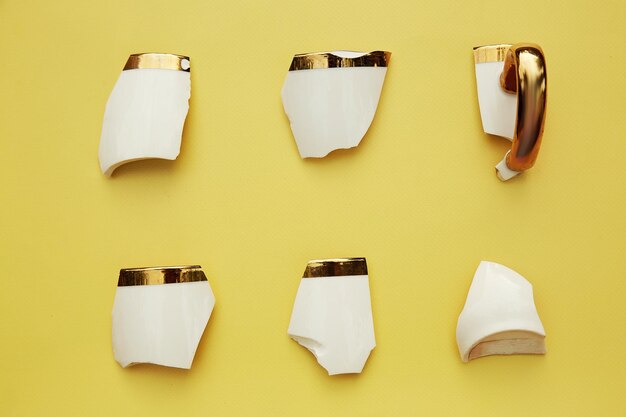 Creative aesthetic broken cup39s pieces on yellow background creative conceptual home decorations idea hope cozy home concept