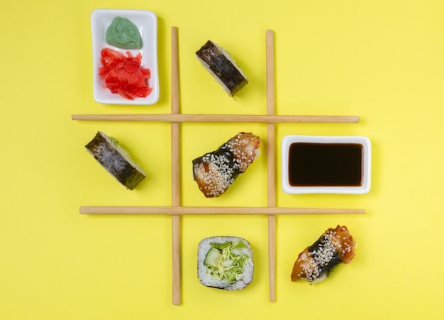 Photo creative arrangement of sushi and sashimi on yellow background for japanese cuisine concept