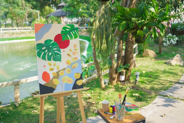Foto concetto di arte creativa capolavoro d'arte in tela su cavalletto con attrezzatura da disegno in giardino