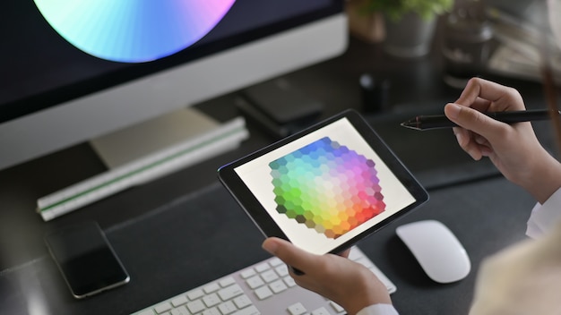 グラフィックタブレットの色の選択に取り組んでいるwebデザインの創造的なアーティスト。