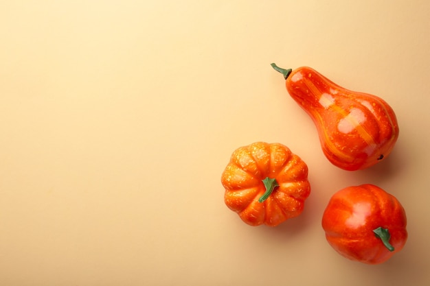 Creative autumn composition. Orange pumpkins on beige background.