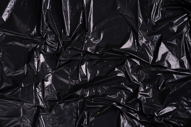 しわくちゃの黒いプラスチックポリエチレンパッケージのクリエイティブな背景