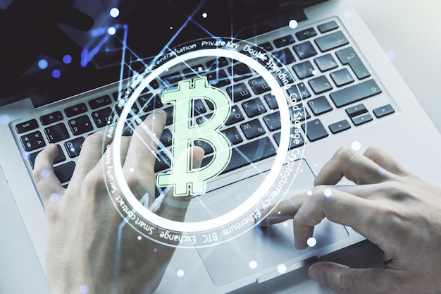 Creative Bitcoin concept with hands typing on laptop on background Multiexposure