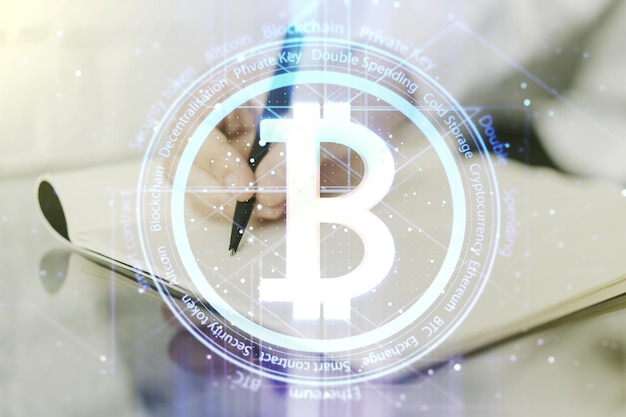 Creative Bitcoin concept with man hand writing in notebook on background Multiexposure