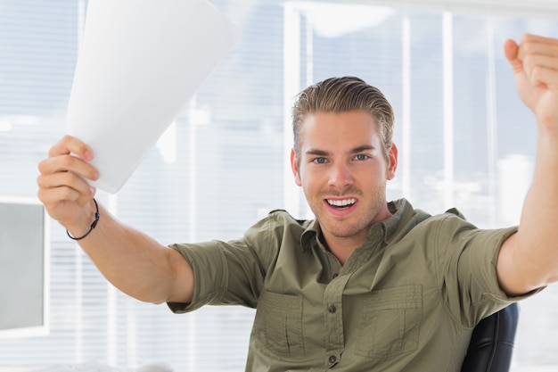 Creative business employee raising his arms