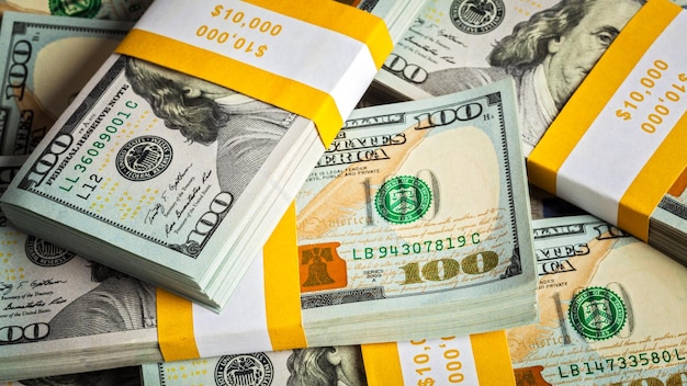 Creative business finance making money concept stacks of US dollars banknotes bills bundles