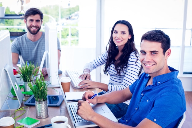 Creative business people using laptop in meeting