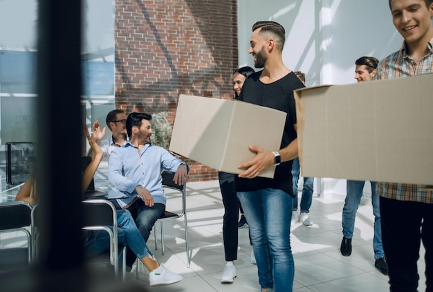 Creative business team brings cardboard boxes to the new officethe concept of a startup