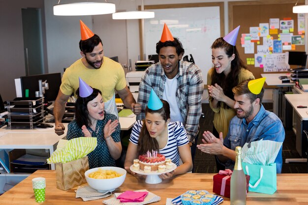 Creative business team celebrating colleagues birthday in office