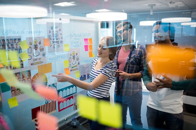 Creative business team reading sticky notes in office