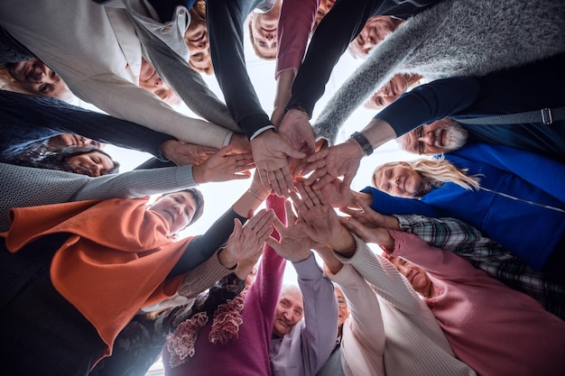 Creative business team stacking hands together in office