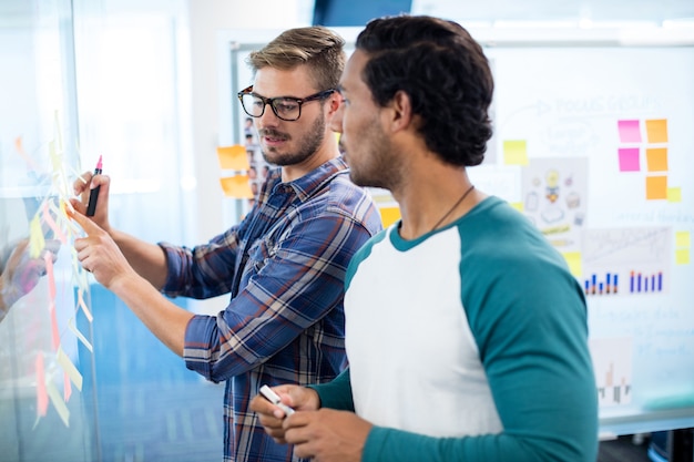 Creative business team writing on the sticky notes in office