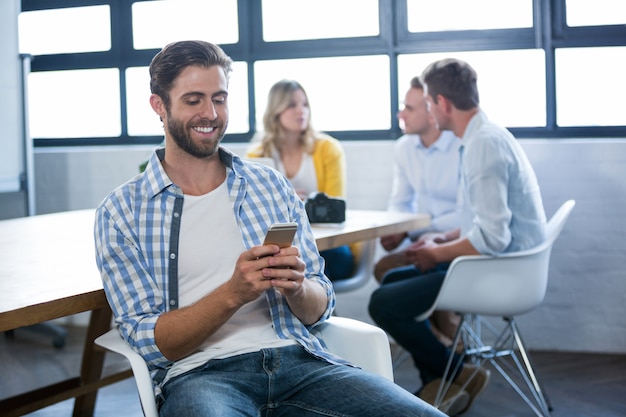 Creative businessman using cellphone by table