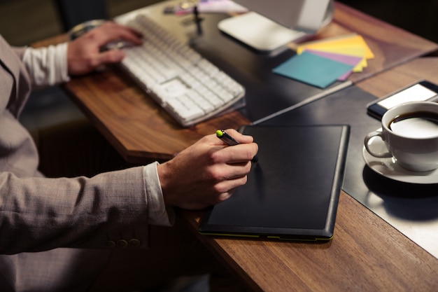 コンピューターとグラフィックタブレットを使用して創造的なビジネスマン