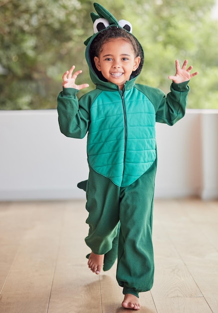 Bambino creativo e costume di halloween da ragazza che corre in un costume da coccodrillo giocando e ridendo a casa fantasia felice e viso di un bambino entusiasta di celebrare un festival divertente godendosi una pausa per giocare