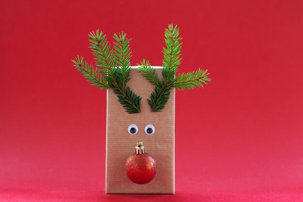 Creative christmas gift box in the form of Santa reindeer red background.