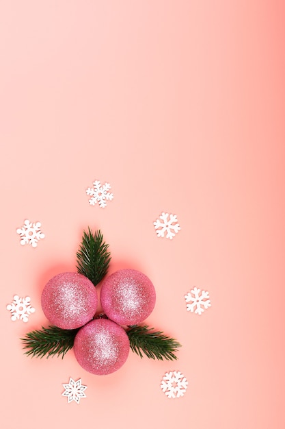 Composizione minimalista creativa in natale. palla di natale su uno sfondo rosa. giocattolo di natale glitter rosa con rami di albero di natale. vista dall'alto, stile piatto, posto vuoto per il testo