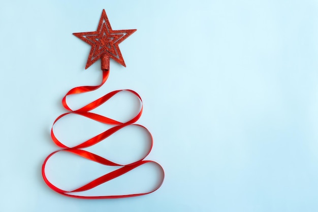 사진 빨간 리본으로 만든 크리에이 티브 크리스마스 트리 및 밝은 파란색 배경 크리스마스 겨울 새 시작