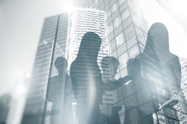 Creative city with businesspeople silhouettes and bright white sky light Wallpaper image Teamwork success and meeting concept Double exposure