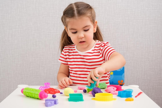 Творческие занятия с пластилином дома девочка лепит разные фигурки из разноцветного пластилина и формочек